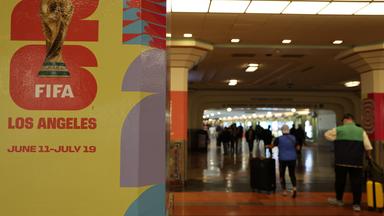 Menschen gehen an einem Plakat zur FIFA-Weltmeisterschaft 2026 in der Union Station in Los Angeles vorbei