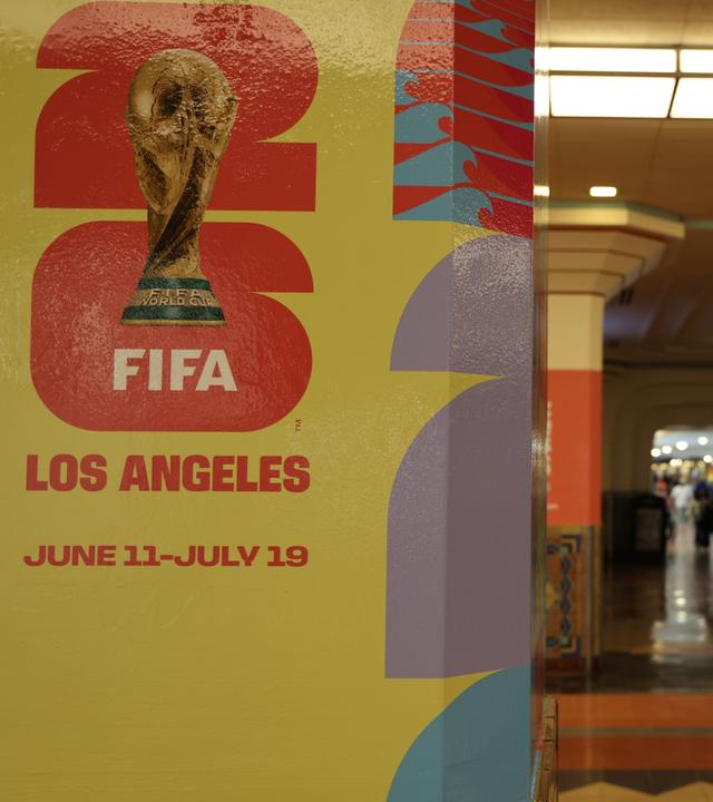 Menschen gehen an einem Plakat zur FIFA-Weltmeisterschaft 2026 in der Union Station in Los Angeles vorbei