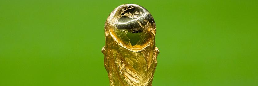 Die WM-Trophäe vor einem grünen Rasen.