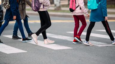 Schüler überqueren einen Zebrastreifen.