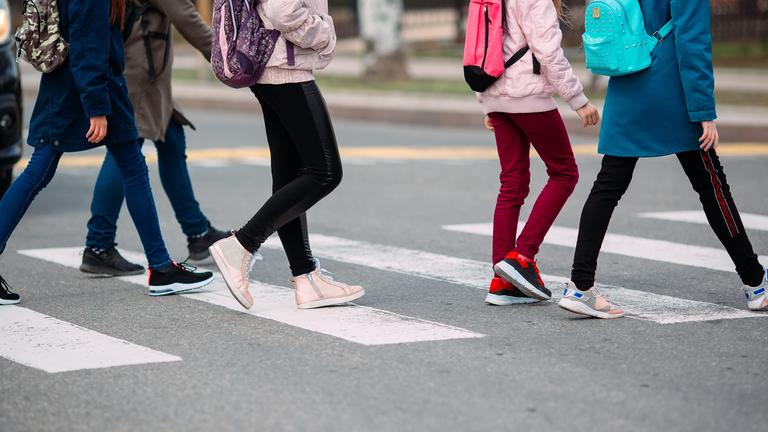 Schüler überqueren einen Zebrastreifen.
