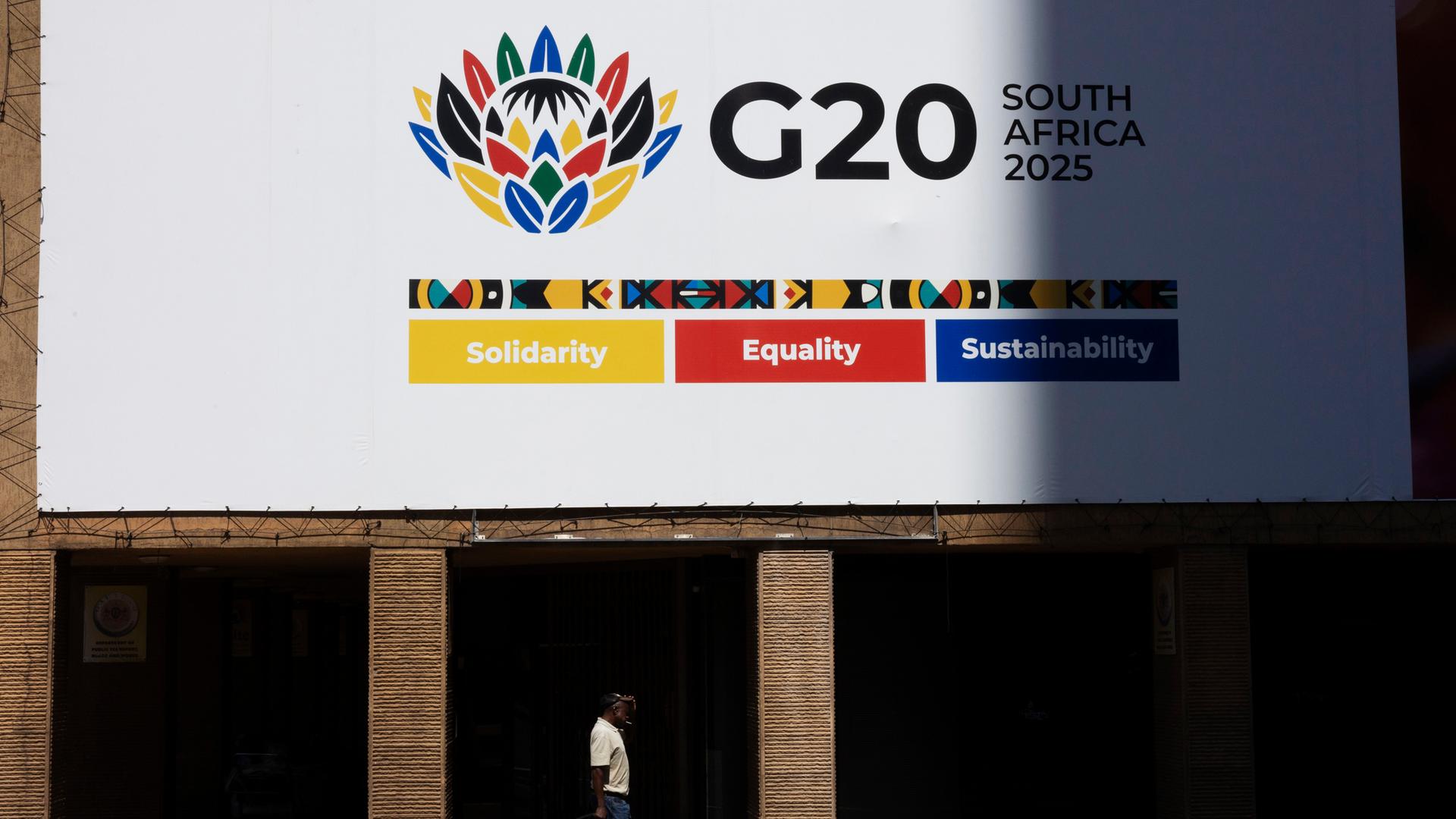 Ein Fußgänger geht an einer Werbetafel zum G20-Gipfel in der Innenstadt von Johannesburg, Südafrika, vorbei.