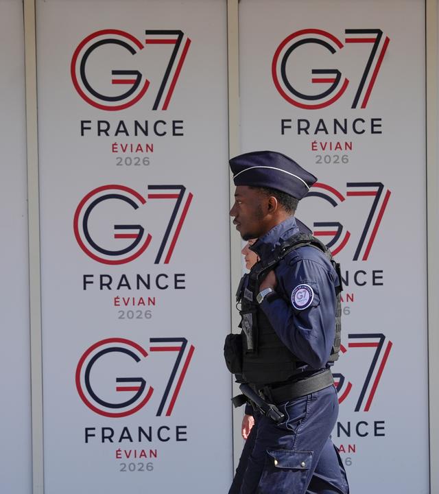Ein französischer Polizist geht in Evian-les-Bains im Osten Frankreichs an G7-Logos vorbei.
