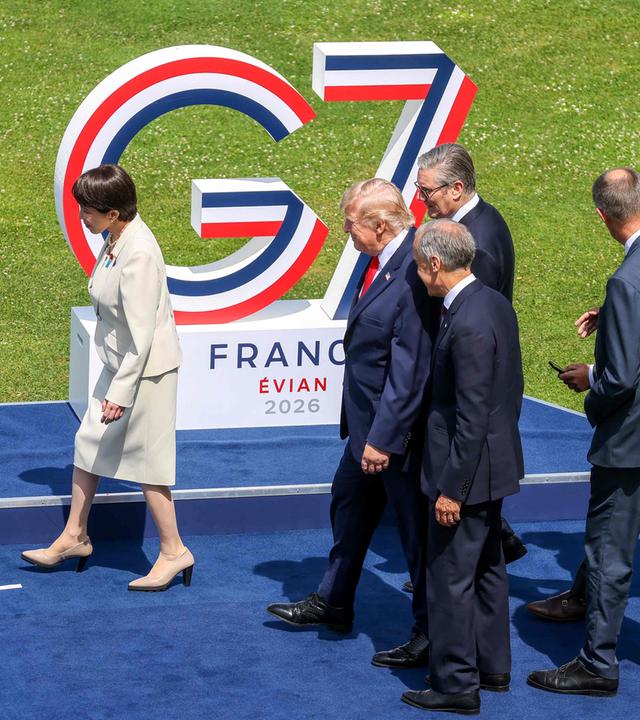 (Von links) Japans Premierministerin Sanae Takaichi, US-Präsident Donald Trump, Kanadas Premierminister Mark Carney, der britische Premierminister Keir Starmer und Deutschlands Bundeskanzler Friedrich Merz begeben sich am 16. 6. 2026 beim G7-Gipfel im ostfranzösischen Évian zu ihren Plätzen für das Gruppenfoto. 