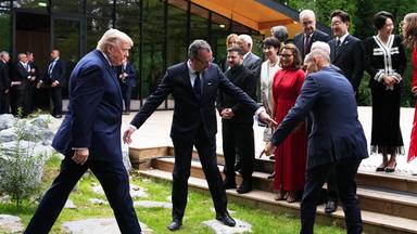 US-Präsident Donald Trump wird dabei unterstützt, sich der Treppe für ein Gruppenfoto der Staats- und Regierungschefs beim G7-Gipfel am Dienstag, dem 16. 6. 2026, in Évian-les-Bains, Frankreich, zu nähern. 