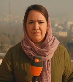 ZDF-Korrespondetin Phoebe Gaa steht mit einem Mikrofon vor Gebäuden in der iranischen Hauptstadt Teheran.