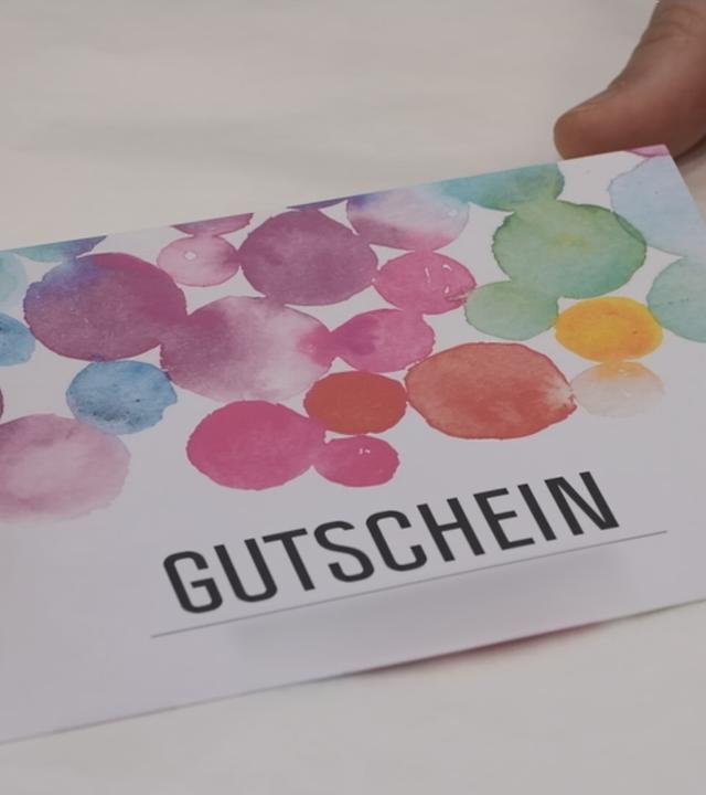 Ein bunter Gutschein auf dem Tisch.