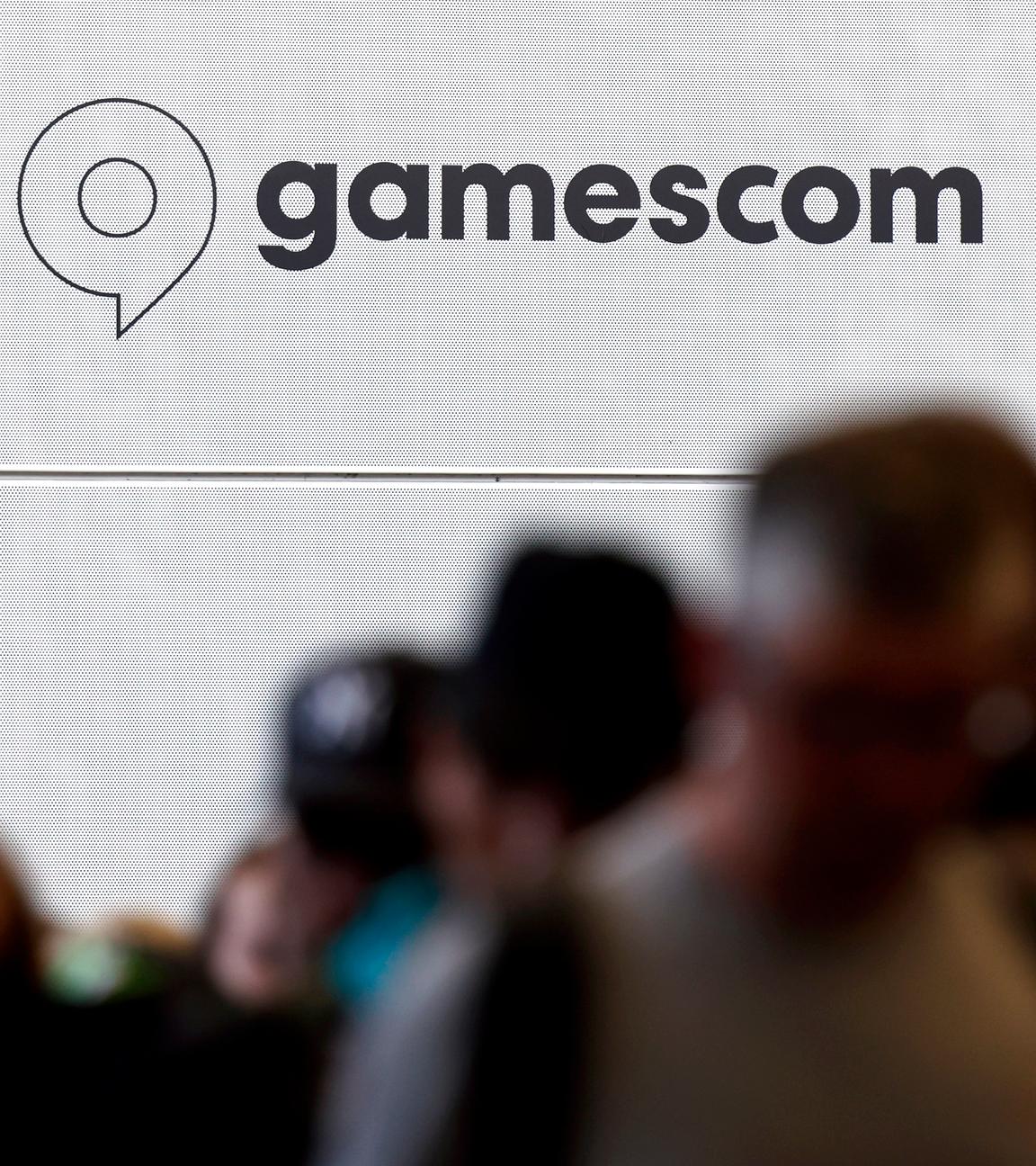 Besucher stehen Schlange vor dem Logo der Gamescom.
