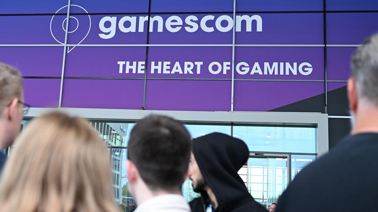 Zu sehen sind mehrere Menschen, die vor dem Gamescom-Gebäude stehen