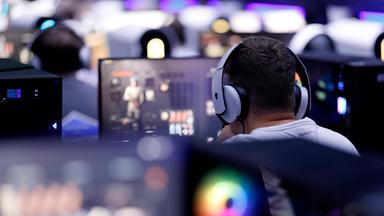 Symbolbild: Besucher testen ein Videospiel (Egoshooter) auf der Gamescom 2024.