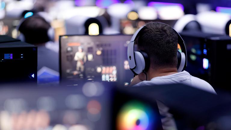 Symbolbild: Besucher testen ein Videospiel (Egoshooter) auf der Gamescom 2024.