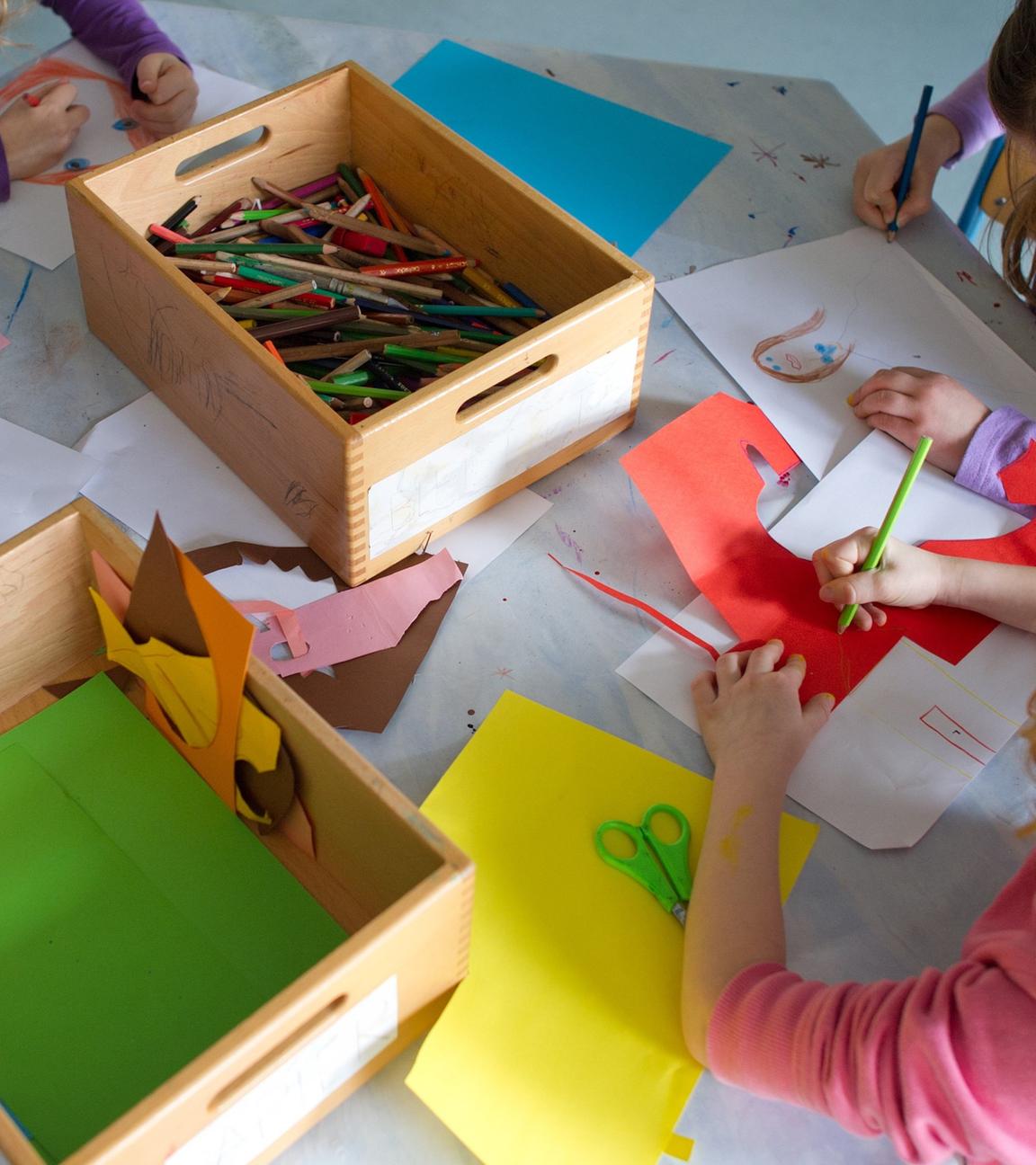 Symbolbild: Grundschülerinnen sind in einem Kinderhort mit Bastelarbeiten beschäftigt.