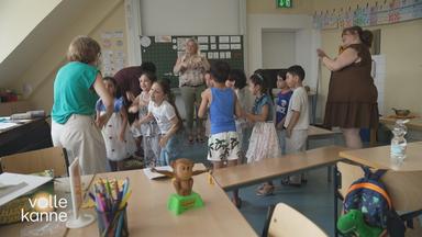 Erzieher und Kindern stehen klatschend im Kreis