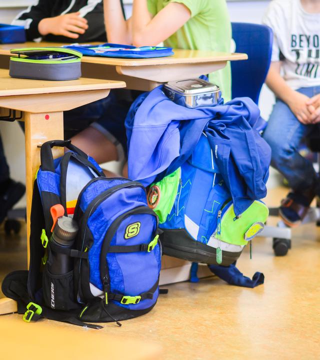Schüler sitzen neben ihren Schulranzen im Klassenraum einer 4. Klasse in der Grundschule.