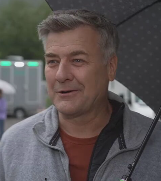 Das Bild zeigt Schauspieler Marcus Mittermeier mit einem Regenschirm am Set.