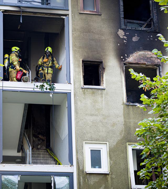 Einsatzkräfte im durch den Brand geschädigten Haus 