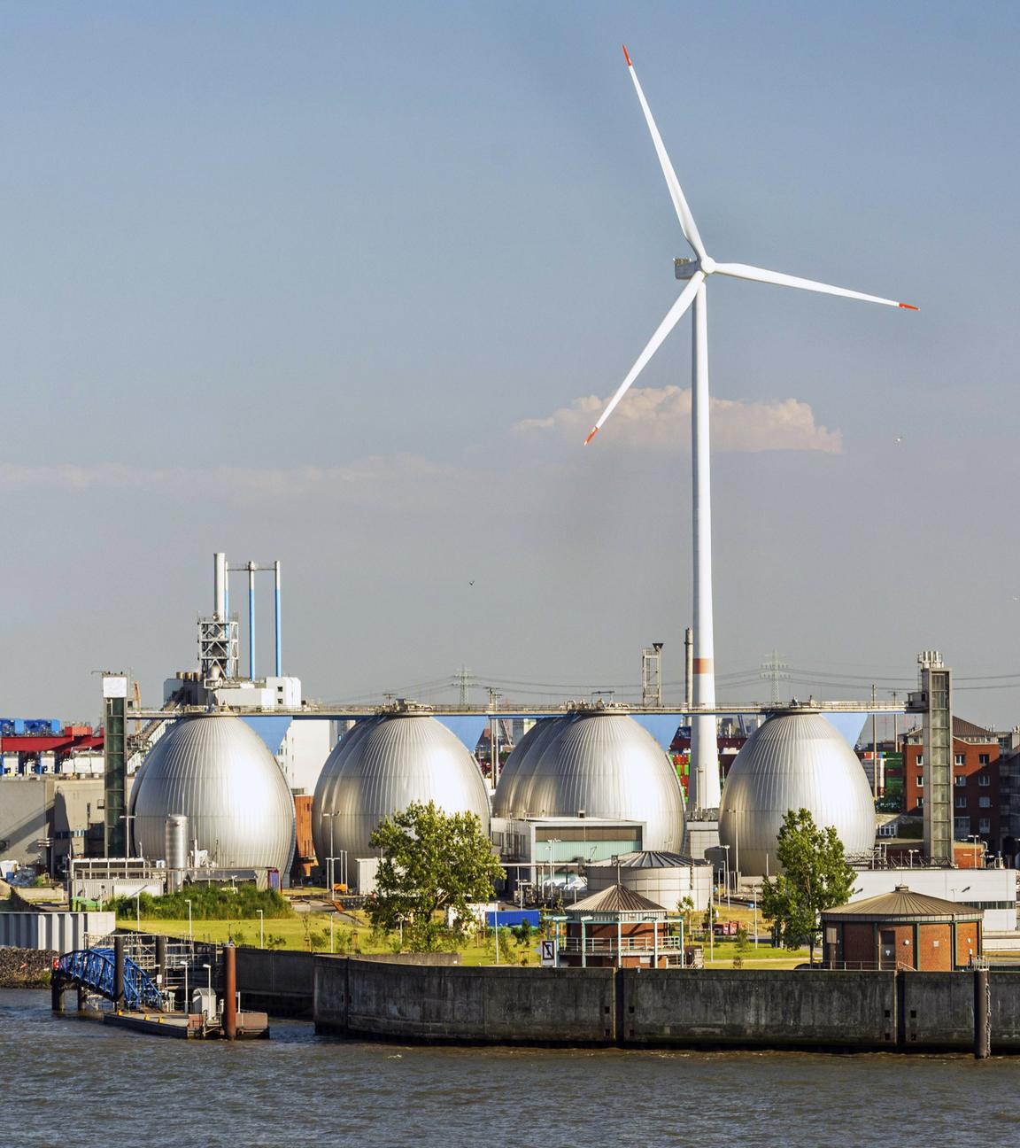 Gasspeicher und große Windkraftanlage im Hafengebiet von Hamburg, Deutschland.