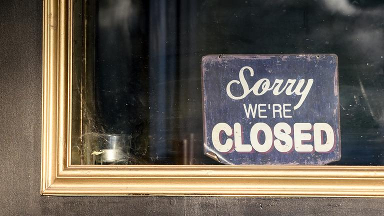 Archiv:  An der Tür eines geschlossenen Restaurants hängt ein Schild mit der Aufschrift "Sorry were closed". 