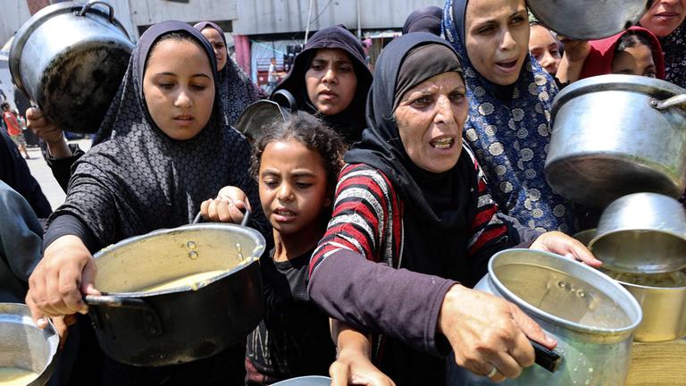 Vertriebene Palästinenser erhalten am 25. Juli 2025 Linsensuppe an einer Essensausgabe in Gaza-Stadt. Hilfsorganisationen warnen vor zunehmender Unterernährung bei Kindern.