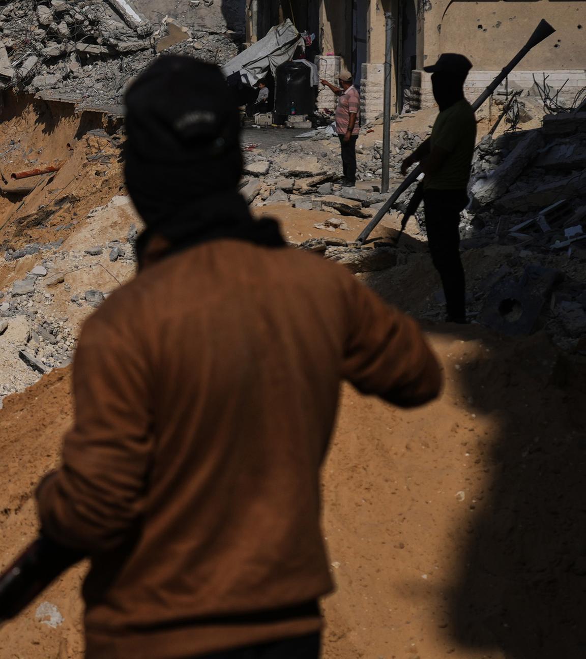 Mitglieder der Hamas-Miliz suchen am Sonntag, dem 19. Oktober 2025, in Khan Yunis im südlichen Gazastreifen unter zerstörten Gebäuden nach den Leichen israelischer Geiseln.