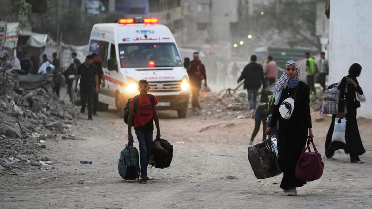 Palästinenser evakuieren, nachdem die israelische Armee eine Evakuierungswarnung für mehrere Schulen und ein Krankenhaus im Stadtteil Rimal in Gaza-Stadt ausgesprochen hat.