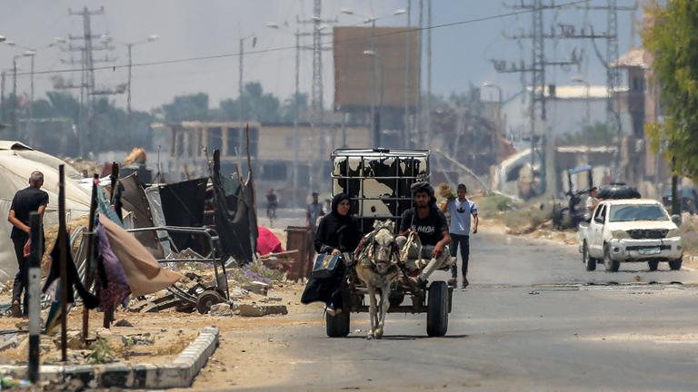 Ein Mann und eine Frau fahren auf einem Wagen, der von einem Esel gezogen wird im zentralen Gaza-Streifen.