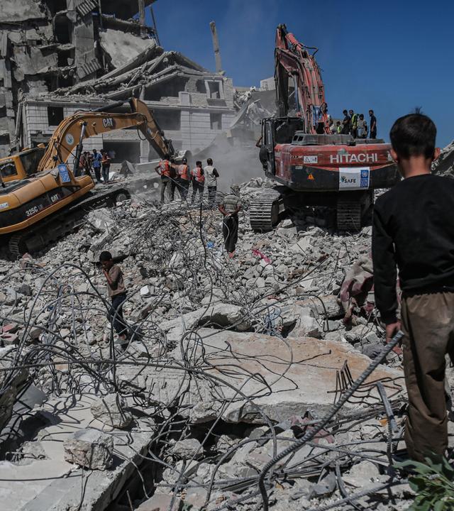 Einsatzkräfte des Zivilschutzes von Gaza retten Menschen aus einem eingestürzten Gebäude im Stadtteil Al-Sinaa westlich von Gaza-Stadt, Gaza.