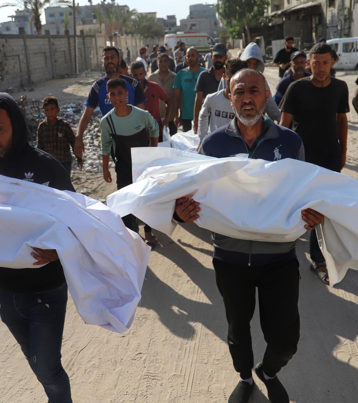 Palestinians carry the bodies of relatives killed in an Israeli strike, at Nasser Hospital in Khan Younis, southern Gaza Strip