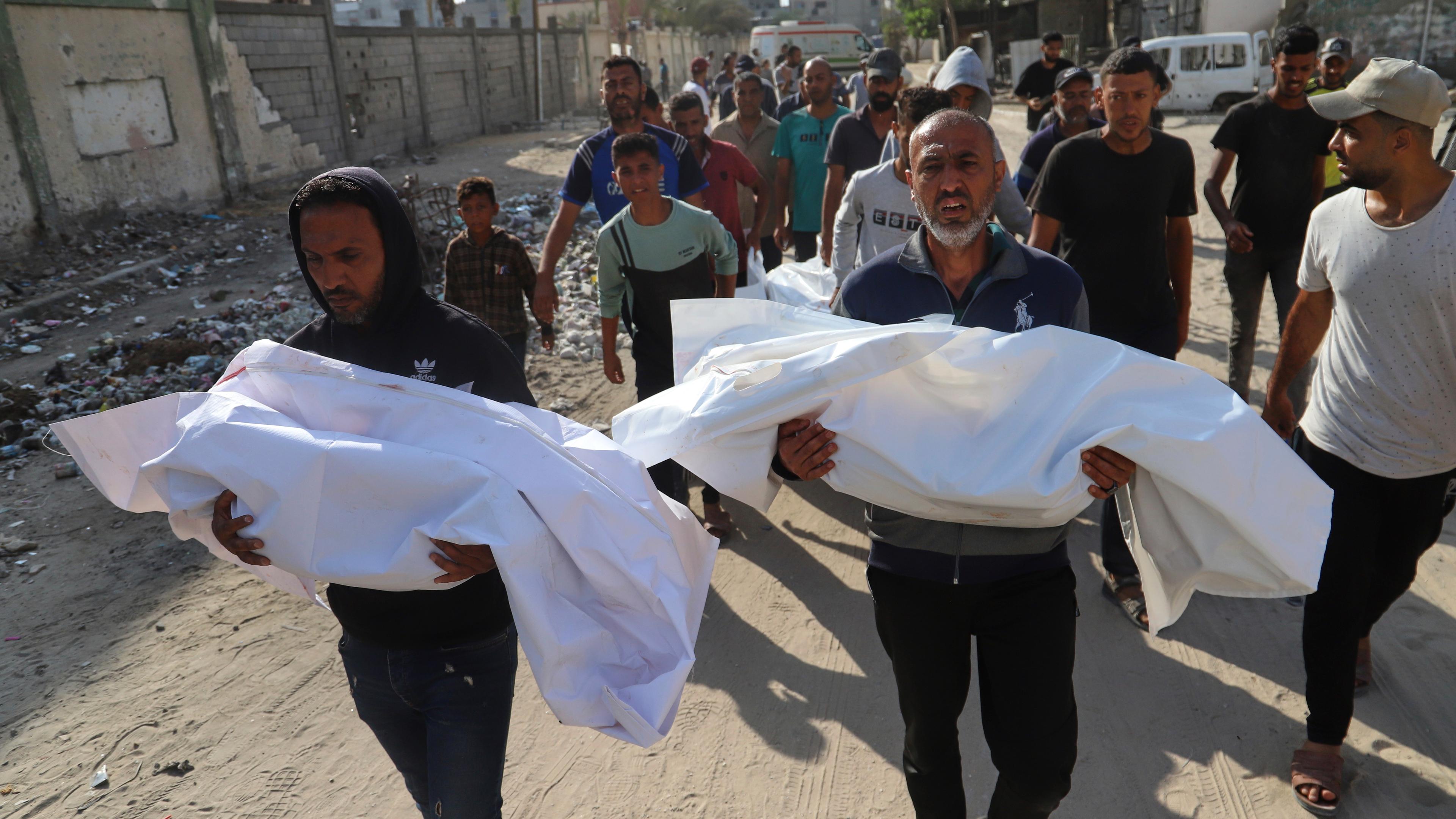 Palestinians carry the bodies of relatives killed in an Israeli strike, at Nasser Hospital in Khan Younis, southern Gaza Strip
