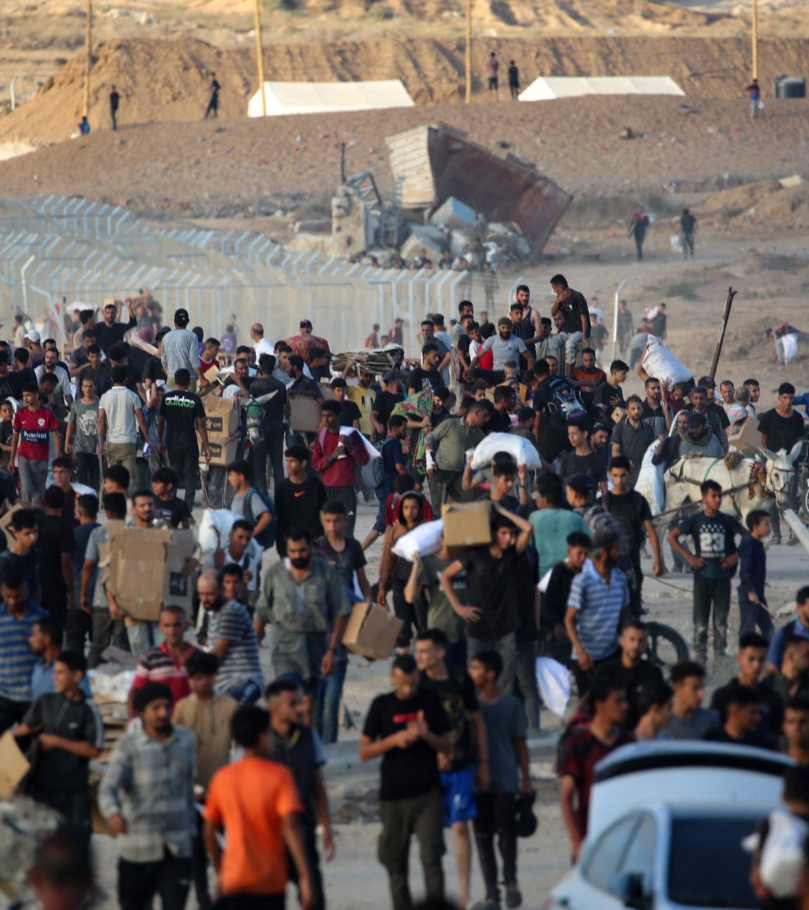 Palestinians gather at an aid distributution point set up by the privately-run Gaza Humanitarian Foundation (GHF), near the Nuseirat refugee camp in the central Gaza Strip on June 25, 2025. (Photo by Eyad BABA / AFP)