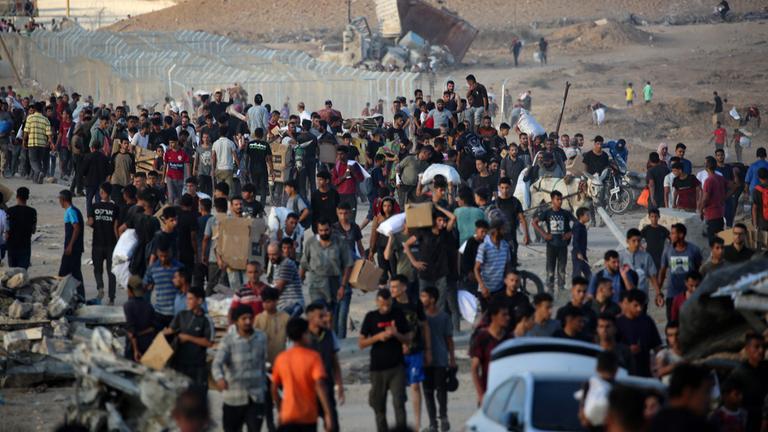 Palestinians gather at an aid distributution point set up by the privately-run Gaza Humanitarian Foundation (GHF), near the Nuseirat refugee camp in the central Gaza Strip on June 25, 2025. (Photo by Eyad BABA / AFP)
