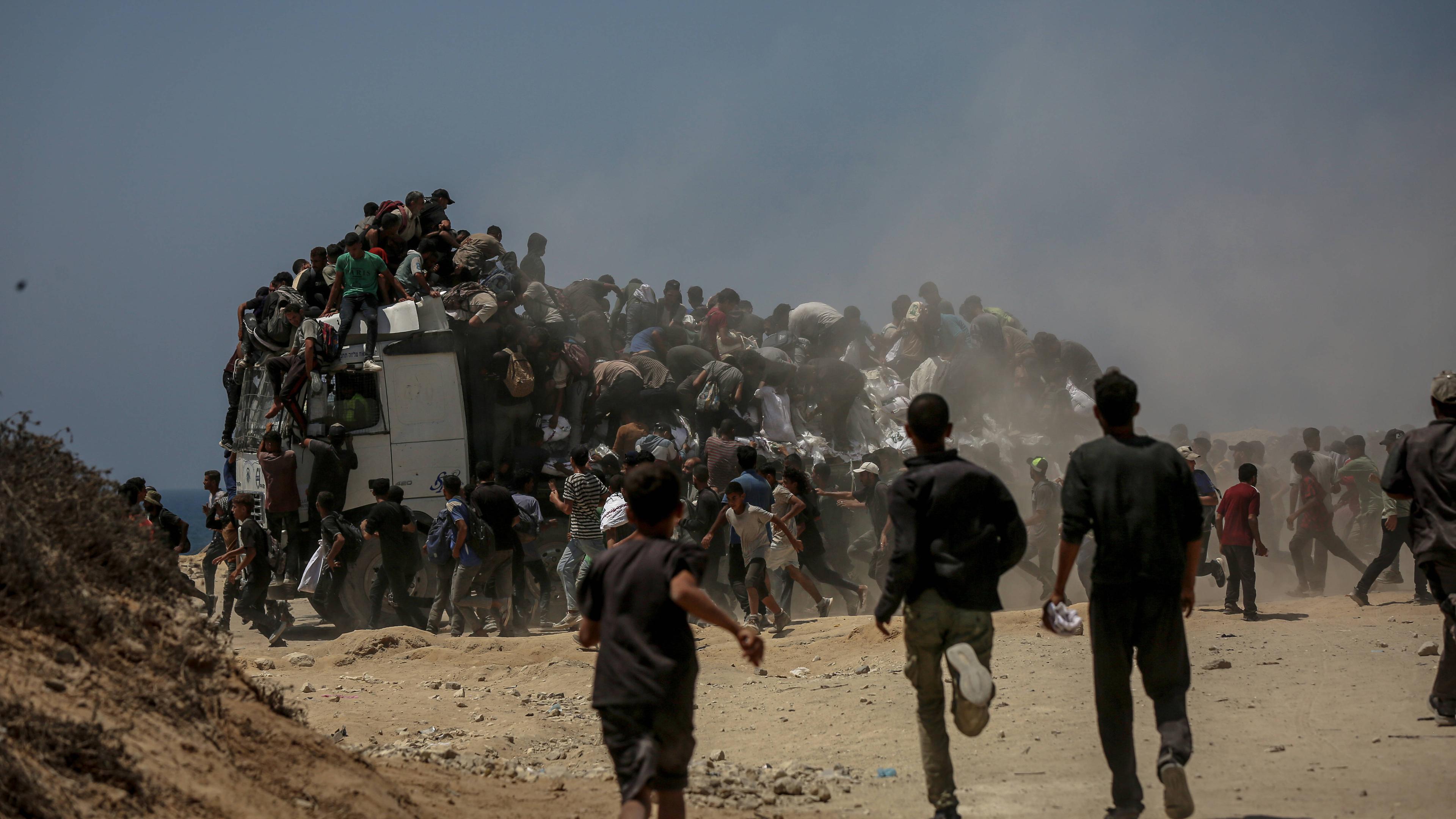 Palästinenser laufen kilometerweit, nachdem sie Mehlhilfen erhalten haben, die von Lastwagen verteilt wurden, die in das Gebiet Zikim, einen Kibbuz im Süden Israels, gefahren sind, während die israelischen Angriffe andauern und es zu schweren Nahrungsmittelengpässen kommt, in Gaza-Stadt, Gaza, am 27. Juli 2025.