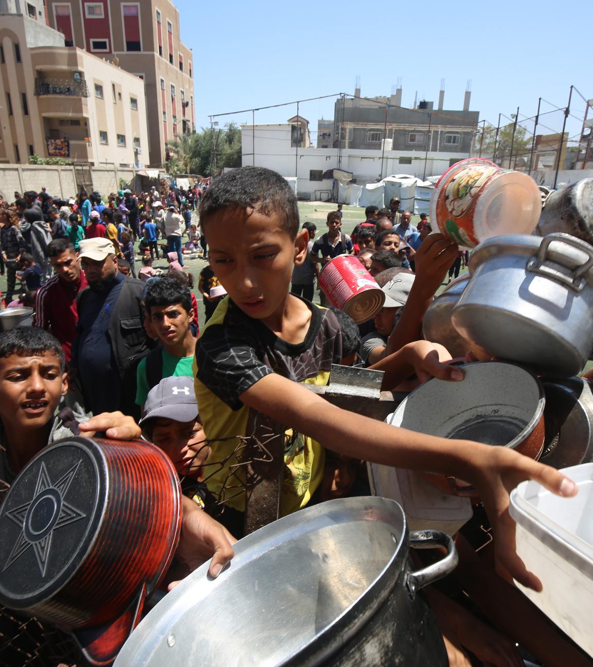 Nuseirat, Gazastreifen, Palästinensisches Gebiet: Binnenvertriebene Palästinenser versammeln sich am 30. Mai 2025 in einer Wohltätigkeitsküche im palästinensischen Flüchtlingslager Nuseirat im Zentrum des Gazastreifens, um angesichts der Nahrungsmittelknappheit begrenzte Rationen zu erhalten.