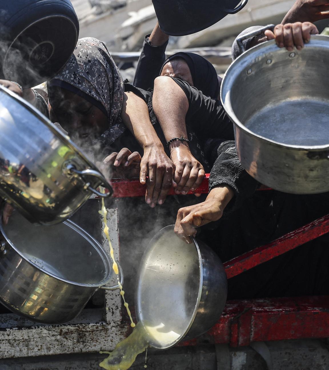 Palästinenser, die Hunger leiden, warten am 23. Juli 2025 in Gaza-Stadt auf eine warme Mahlzeit, die von einer Wohltätigkeitsorganisation verteilt wird, da die Menschen keinen Zugang zu Lebensmitteln haben.