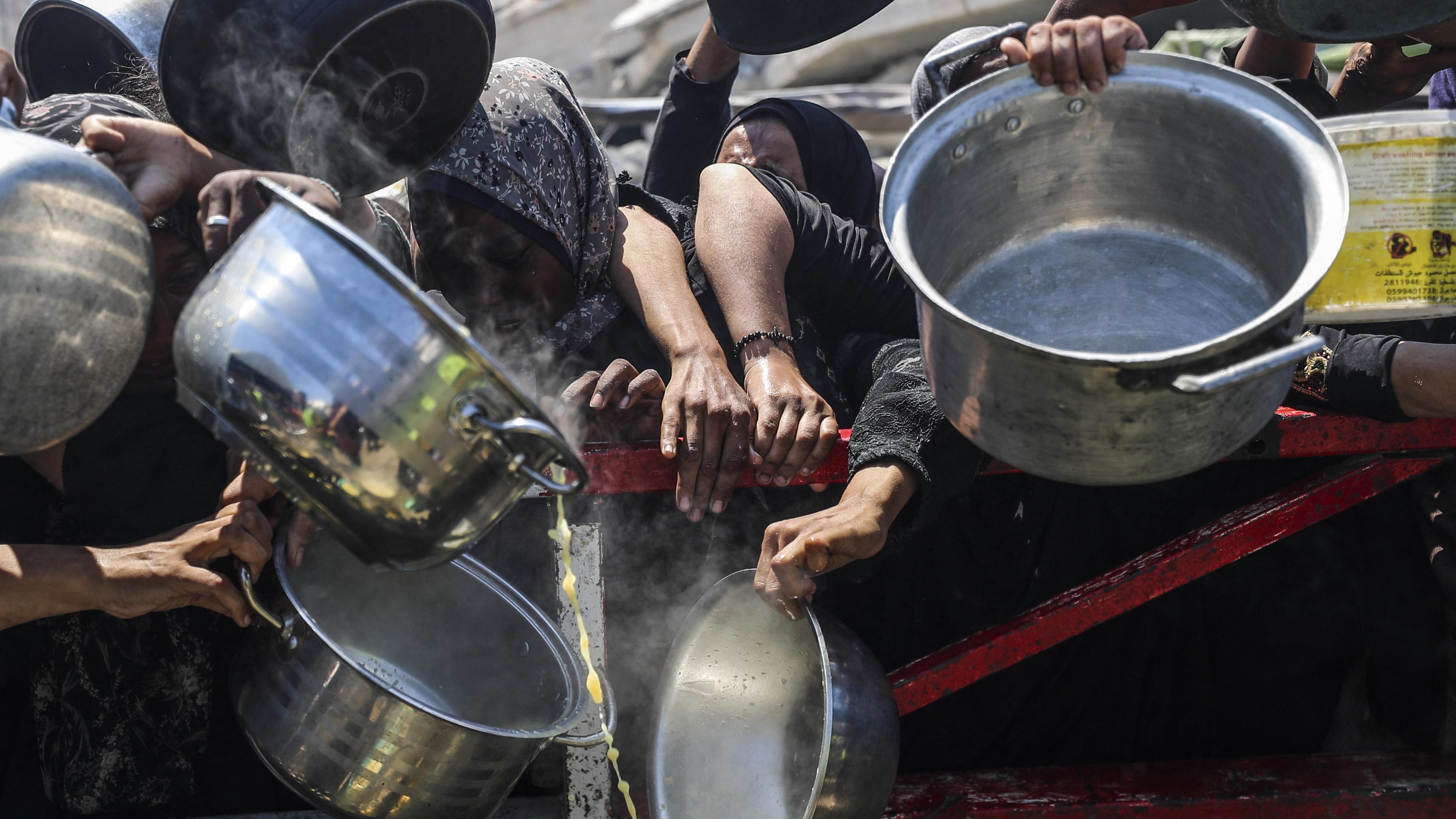 Palästinenser, die Hunger leiden, warten am 23. Juli 2025 in Gaza-Stadt auf eine warme Mahlzeit, die von einer Wohltätigkeitsorganisation verteilt wird, da die Menschen keinen Zugang zu Lebensmitteln haben.