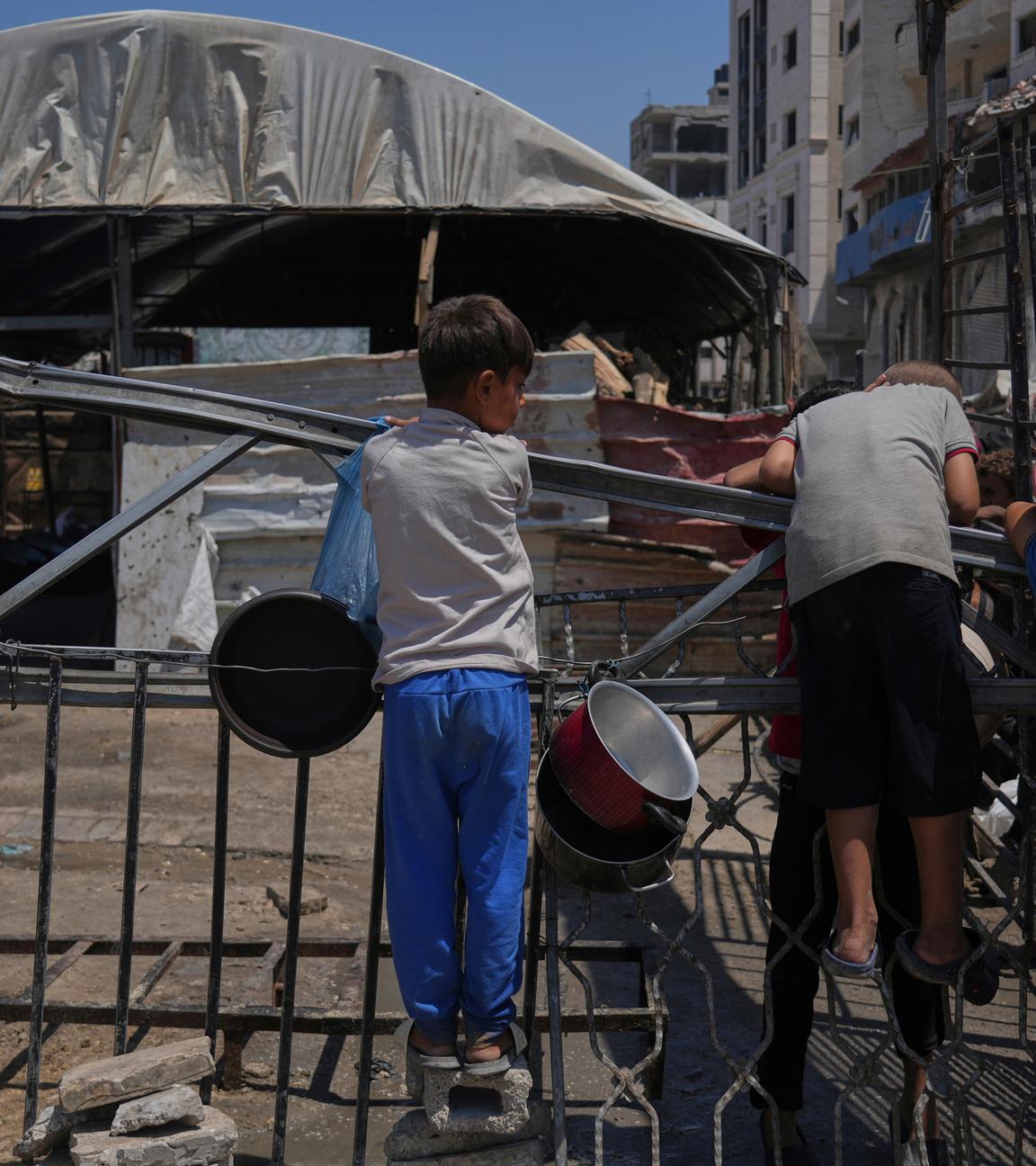 A Palestinian children wait at a community kitchen before donated food is prepared and distributed in Gaza