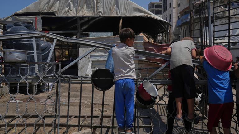 A Palestinian children wait at a community kitchen before donated food is prepared and distributed in Gaza