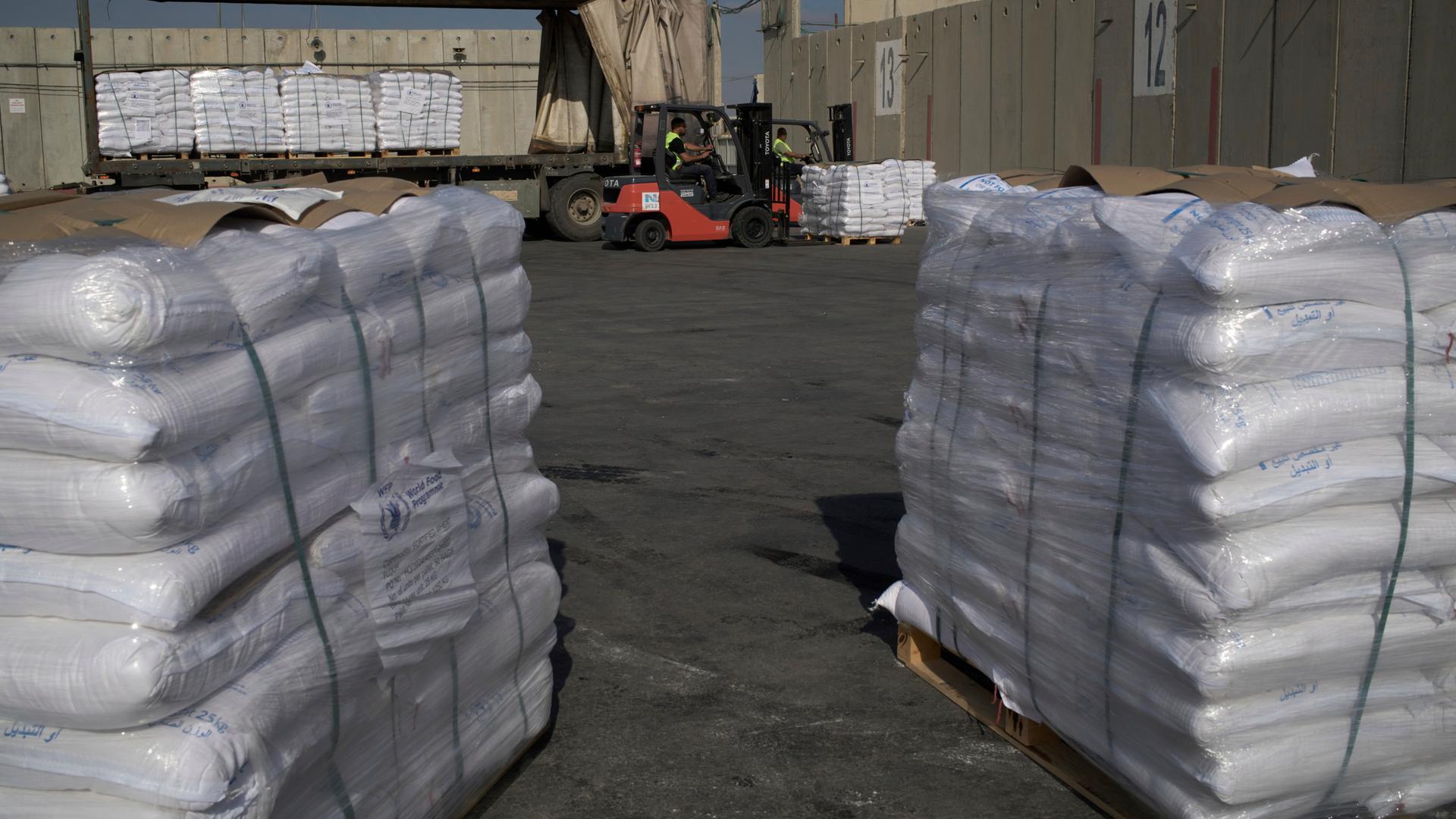 Gestapelte und in weiße Verpackung gehüllte Hilfsgüter auf Paletten