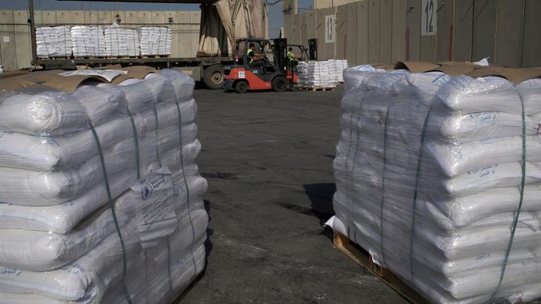 Gestapelte und in weiße Verpackung gehüllte Hilfsgüter auf Paletten