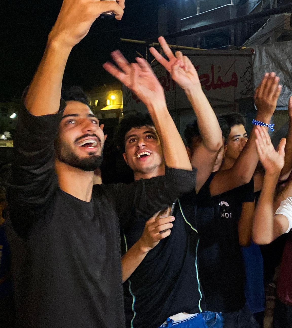 Khan Yunes, Palästinensiche Gebiete: Mehrere Menschen feiern auf einer Straße nach der Verkündung, dass Israel und die Hamas sich auf die Umsetzung der ersten Phase des Friedensplans geeinigt haben.