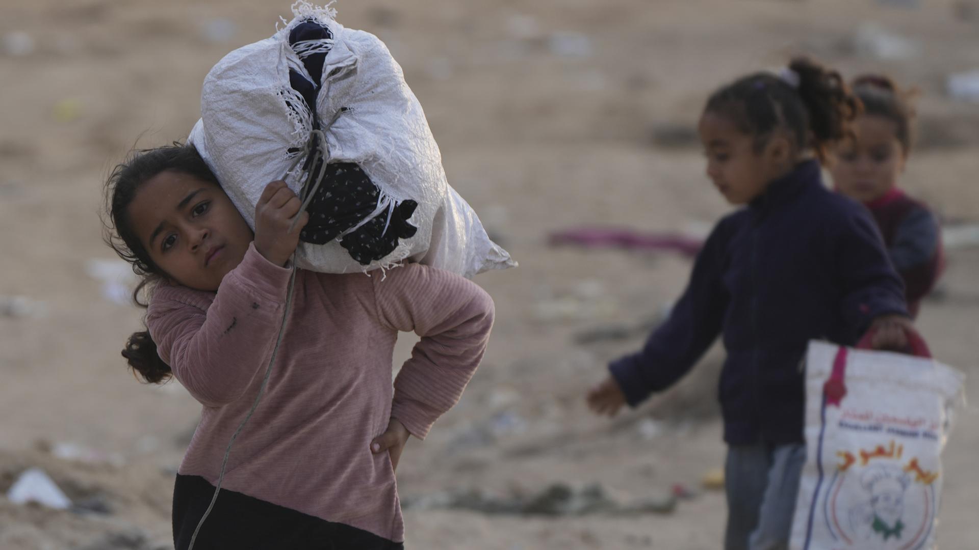 Vertriebene palästinensische Kinder gehen auf einer Straße im nördlichen Gazastreifen, um in ihre Häuser zurückzukehren.