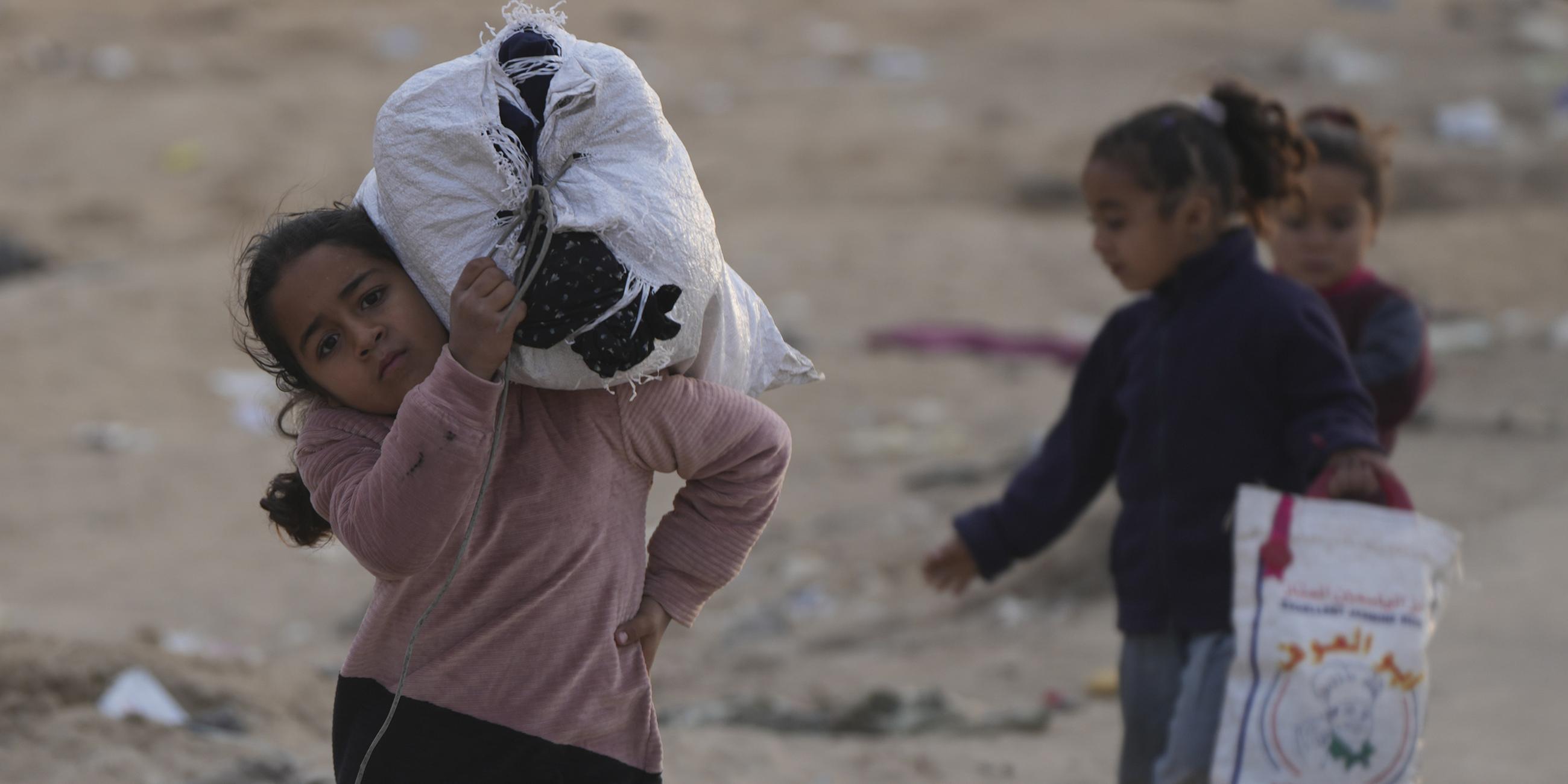 Vertriebene palästinensische Kinder gehen auf einer Straße im nördlichen Gazastreifen, um in ihre Häuser zurückzukehren.