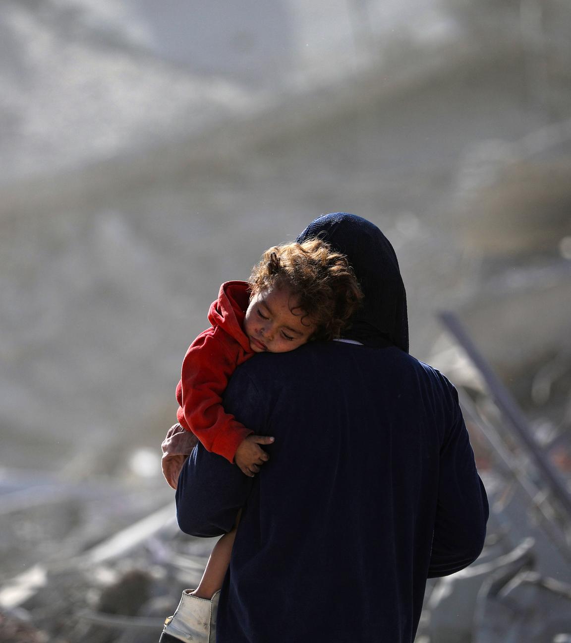 Eine palästinensische Mutter mit ihrem Kind geht während eines Waffenstillstands zwischen Israel und der Hamas in Gaza-Stadt am 11. 10. 2025 durch die Trümmer zerstörter Gebäude. 