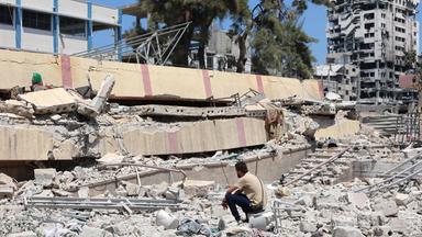 Ein Mann sitzt in den Trümmern eines zerstörten Gebäudes im Gazastreifen.