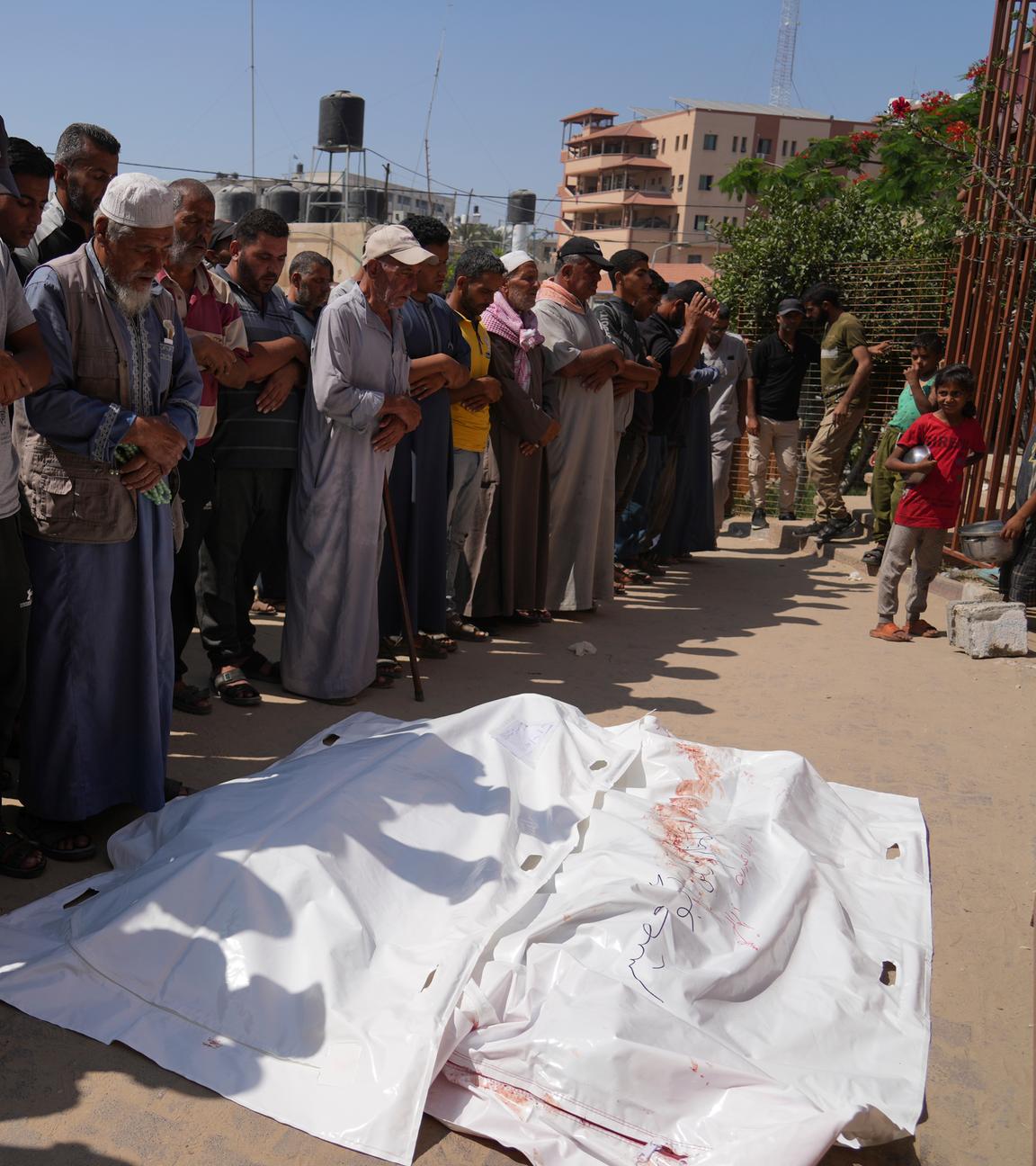 Palästinenser beten vor den Leichen von Ahmed Abu Hilal und Ibrahim Al-Najjar, die auf dem Weg zu einem Hilfszentrum in Gaza getötet wurden.