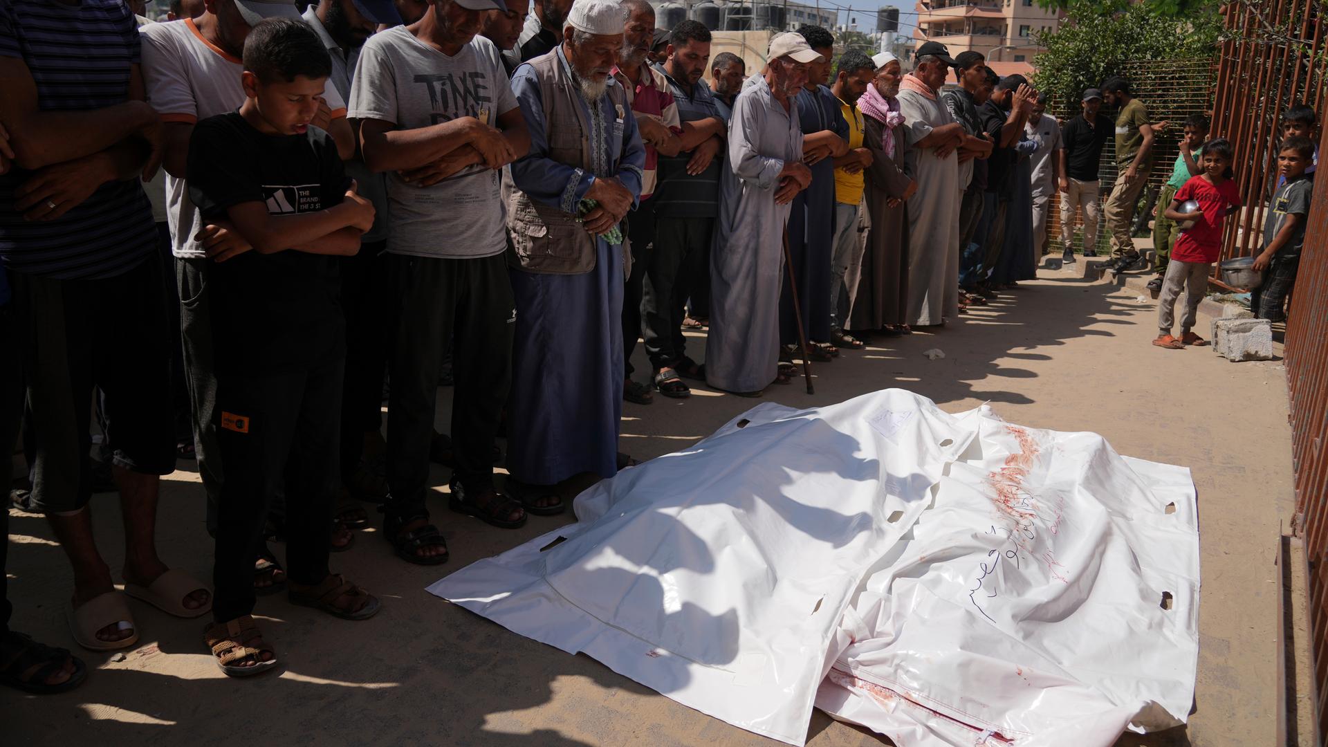 Palästinenser beten vor den Leichen von Ahmed Abu Hilal und Ibrahim Al-Najjar, die auf dem Weg zu einem Hilfszentrum in Gaza getötet wurden.