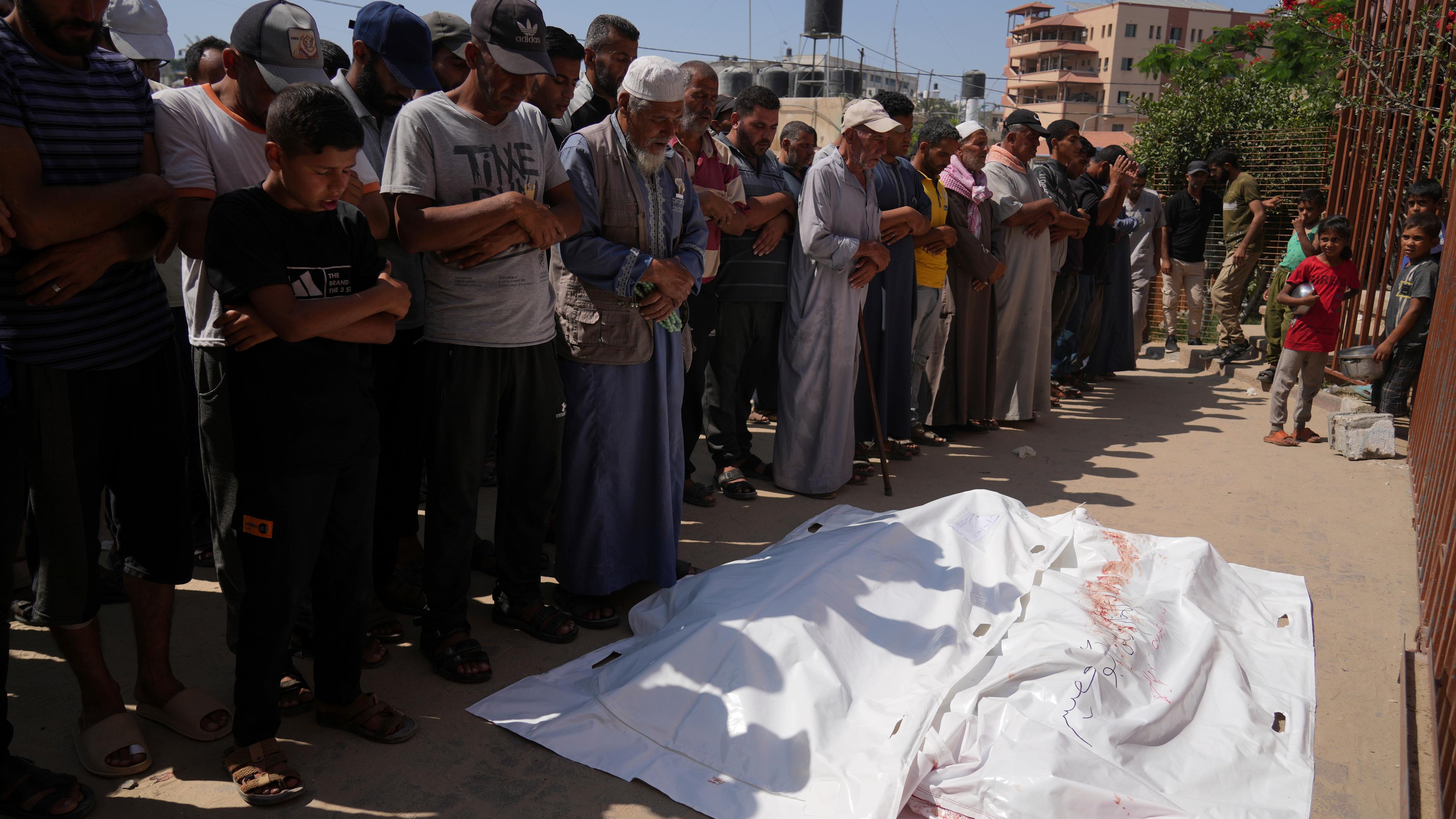 Palästinenser beten vor den Leichen von Ahmed Abu Hilal und Ibrahim Al-Najjar, die auf dem Weg zu einem Hilfszentrum in Gaza getötet wurden.