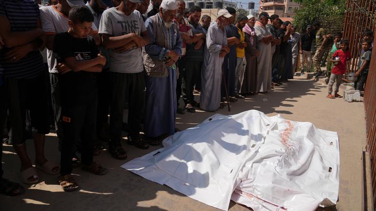 Palästinenser beten vor den Leichen von Ahmed Abu Hilal und Ibrahim Al-Najjar, die auf dem Weg zu einem Hilfszentrum in Gaza getötet wurden.