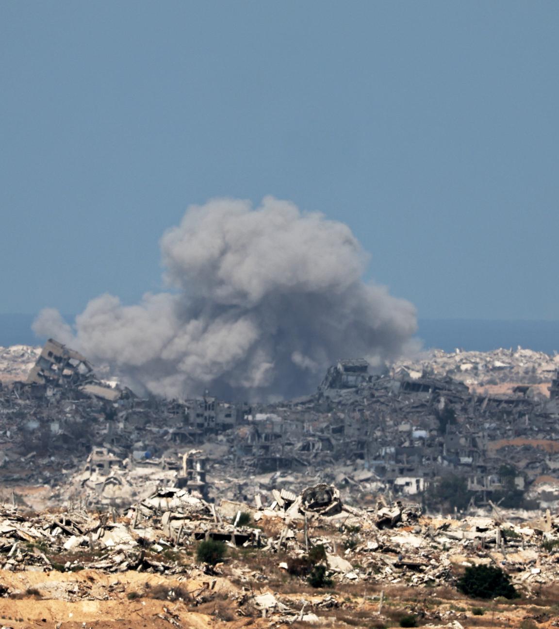 Gaza-Stadt: Rauch steigt nach einem Luftangriff empor. Überall liegen Trümmer von zerstörten Gebäuden.