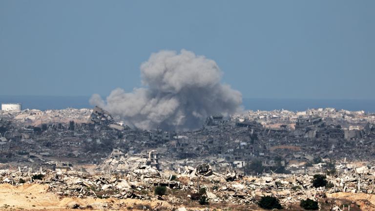 Gaza-Stadt: Rauch steigt nach einem Luftangriff empor. Überall liegen Trümmer von zerstörten Gebäuden.